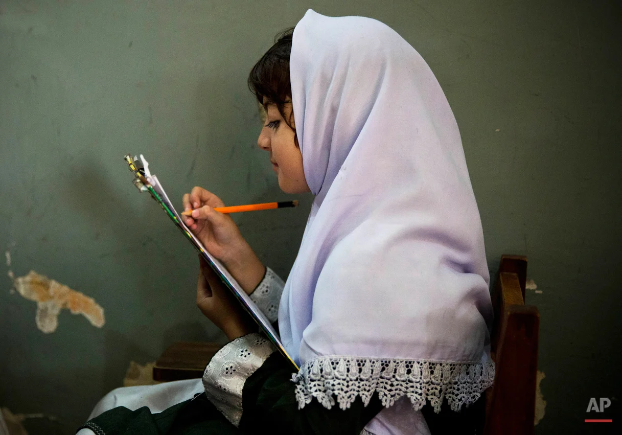 In this Saturday, Oct. 5, 2013 photo, a young Pakistani girl works on her mid-term papers in a school in Mingora, Swat Valley, Pakistan. Malala Yousafzai's struggle for girls to be educated in a deeply conservative society led to her shooting by the Taliban two years ago, while her relentless campaign for women's was rewarded Friday, Oct. 10, 2014, by the recognition of her work as she was jointly awarded the Nobel Peace Prize. (AP Photo/Anja Niedringhaus)