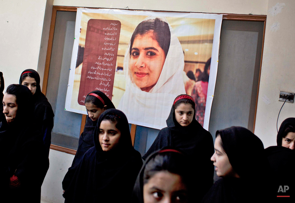  In this Thursday, Nov. 15, 2012 photo, Pakistani girls gather under a poster of Malala Yousufzai in her old school in Mingora, Swat Valley, Pakistan. Taliban attack survivor Malala Yousafzai of Pakistan won the Nobel Peace Prize on Friday, Oct. 10, 
