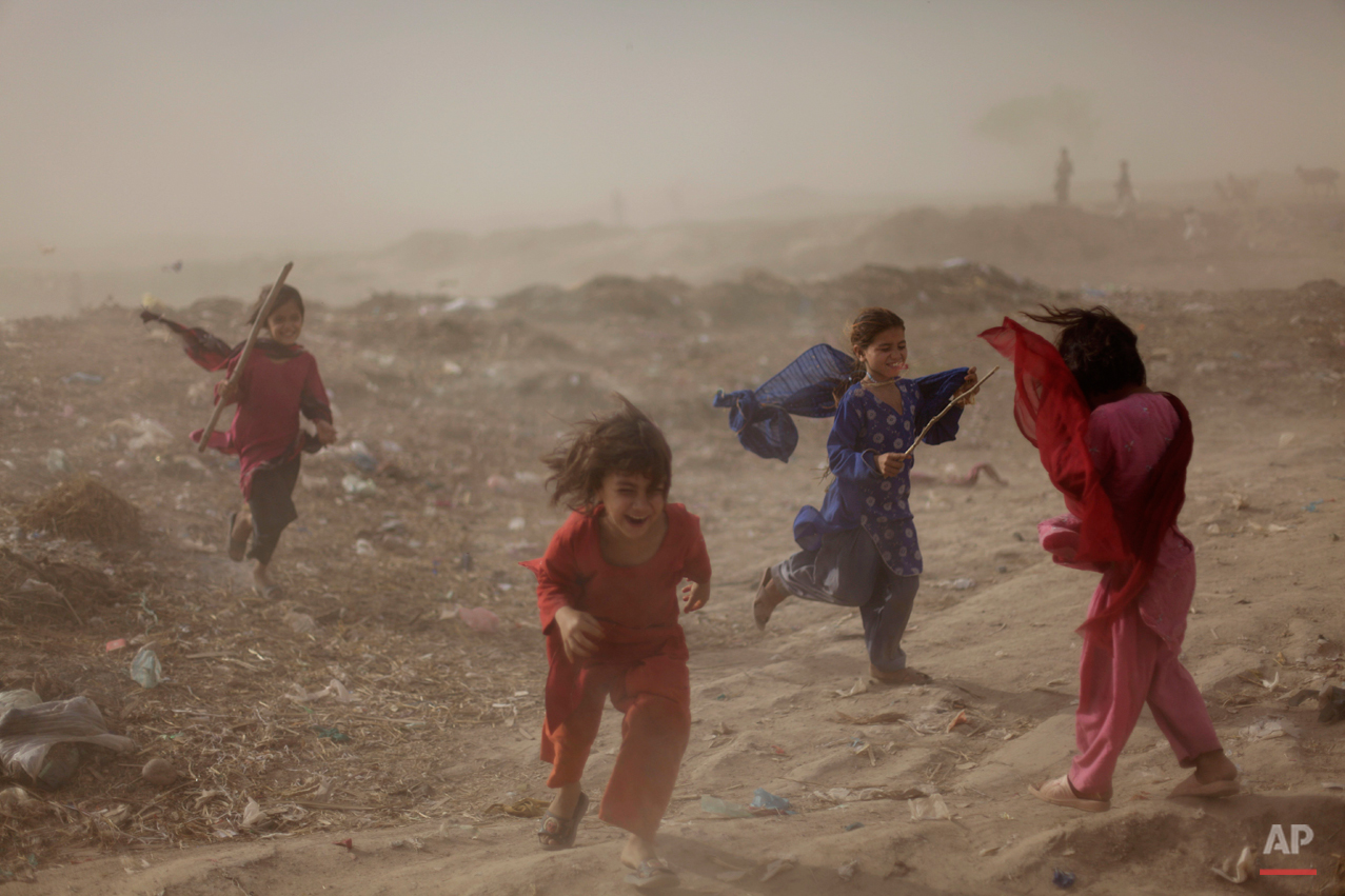  Pakistani girls react as they get caught in a sand storm, in a slum on the outskirts of Islamabad, Pakistan, Wednesday, May 25, 2011. (AP Photo/Muhammed Muheisen) 