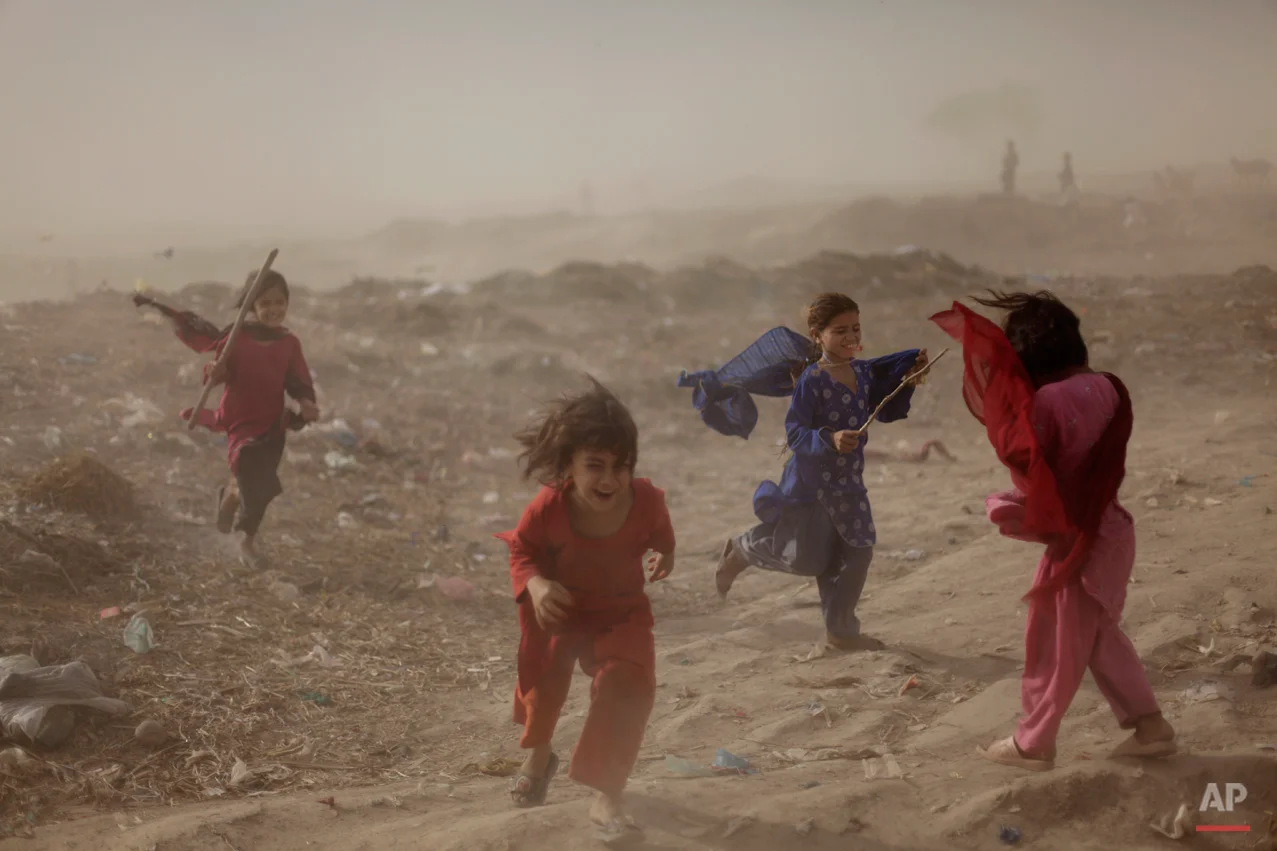 Pakistani girls react as they get caught in a sand storm, in a slum on the outskirts of Islamabad, Pakistan, Wednesday, May 25, 2011. (AP Photo/Muhammed Muheisen)