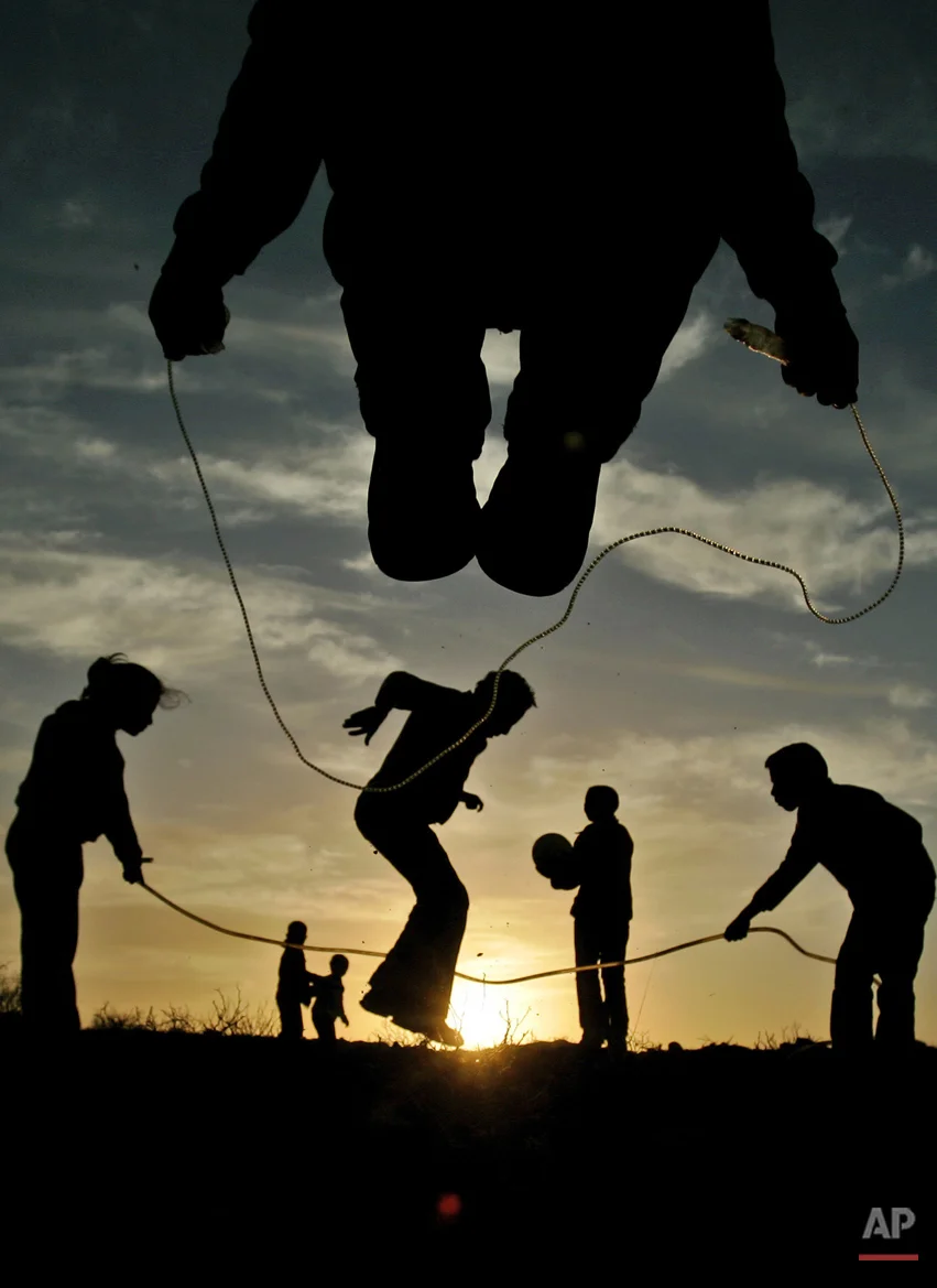 Palestinian youths and children play during sunset in the West Bank city of Ramallah, Saturday, Feb. 9, 2008. (AP Photo/Muhammed Muheisen)