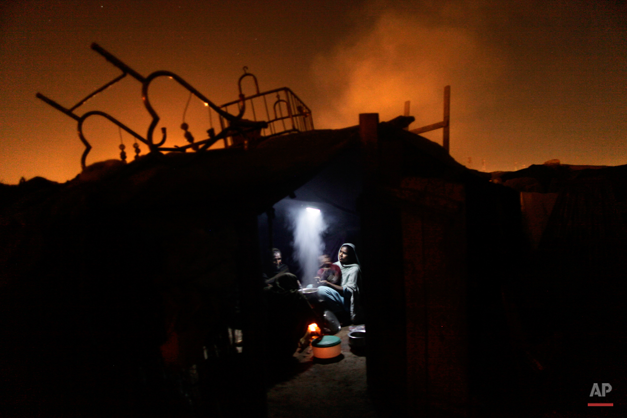  Pakistani women cook for their family using a fire inside their makeshift home, in a slum in Islamabad, Pakistan, Monday, March 4, 2013. Slums which are built on illegal lands have neither running water or sewage disposal. (AP Photo/Muhammed Muheise