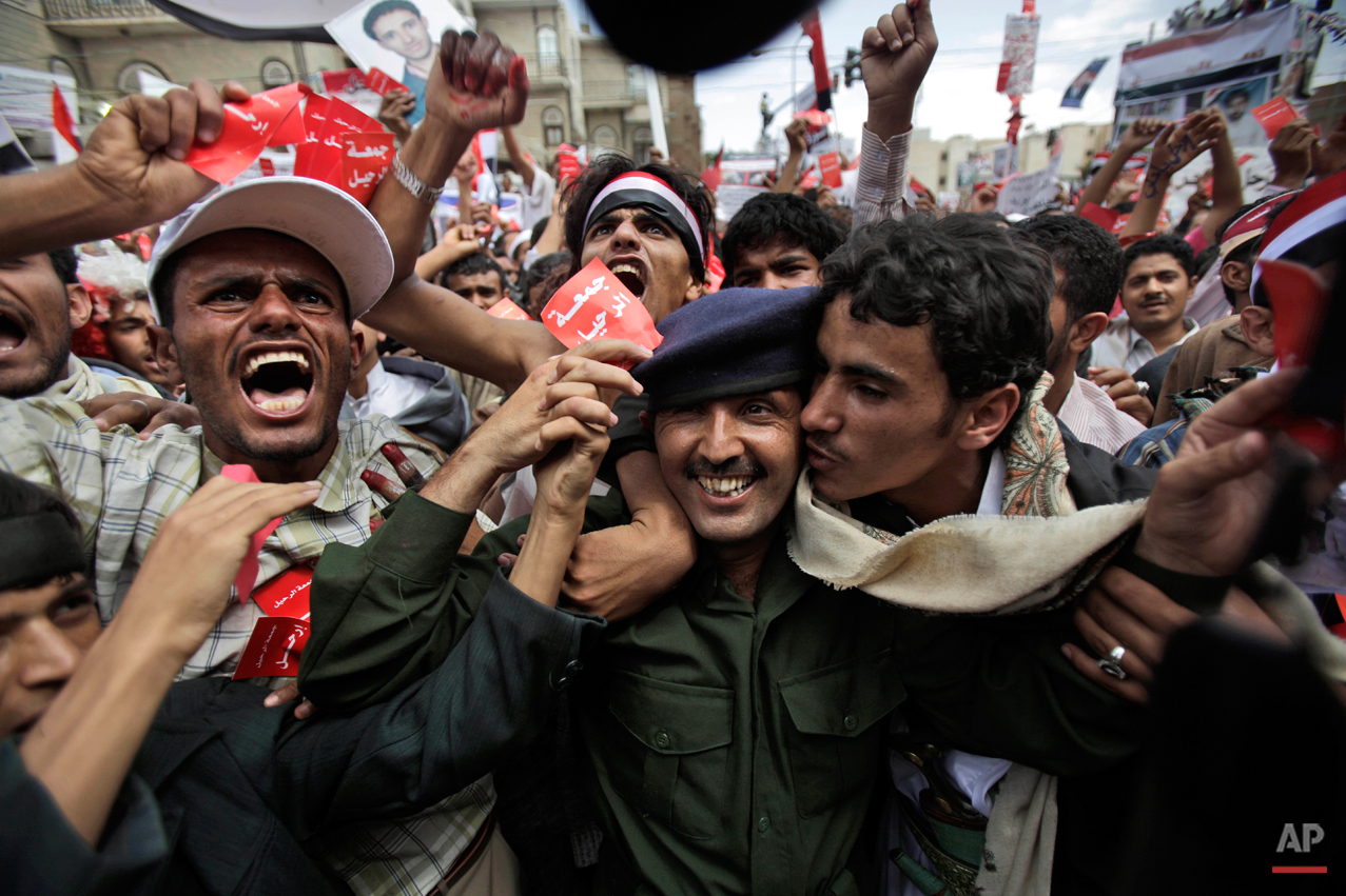  A Yemeni army officer, center, is kissed by an anti-government protestor during a demonstration demanding the resignation of Yemeni President Ali Abdullah Saleh, in Sanaa,Yemen, Friday, March 25, 2011. Facing growing calls for his resignation, Yemen