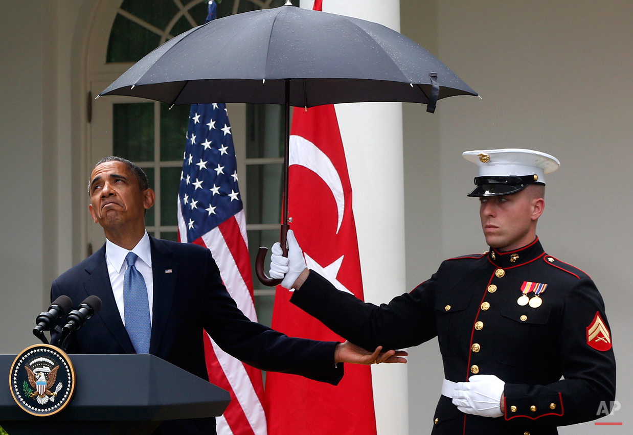  President Barack Obama looks to see if it is still raining as a Marine holds an umbrella for him during his joint news conference with Turkish Prime Minister Recep Tayyip Erdogan, not pictured, Thursday, May 16, 2013, in the Rose Garden of the White