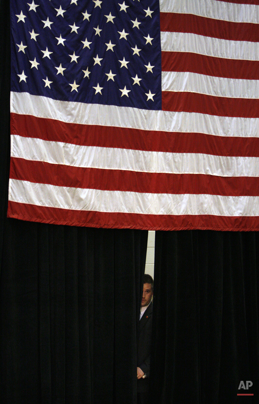  A Secret Service agent looks out from backstage before the arrival of Democratic presidential hopeful, Sen. Hillary Rodham Clinton, D-N.Y., at a campaign rally at Muncie Central High School in Muncie, Ind., Friday, March 28, 2008. (AP Photo/Charles 