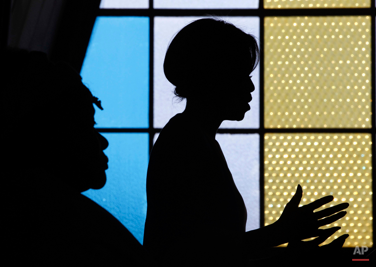  U.S. first lady Michelle Obama is seen in silhouette as she speaks at Regina Mundi Church and addresses the Young African Women Leaders Forum in a Soweto township, Johannesburg, South Africa, Wednesday, June 22, 2011. (AP Photo/Charles Dharapak, Poo