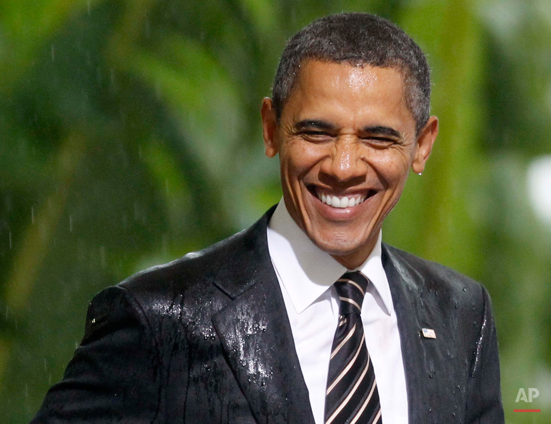  President Barack Obama smiles in the rain as he and French President Nicolas Sarkozy attend an event honoring the alliance between the United States and France and their efforts in Libya , Friday, Nov. 4, 2011, at Cannes City Hall, after the G20 Sum