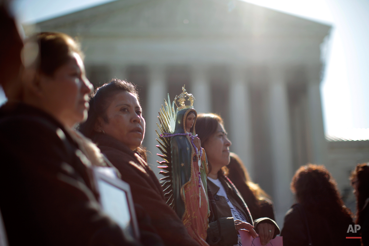  Leonida Martinez, from Phoenix, Ariz., second from left, and others take part in a demonstration in front of the Supreme Court in Washington, Wednesday, April 25, 2012, as the court questions Arizona's "show me your papers" immigration law. (AP Phot