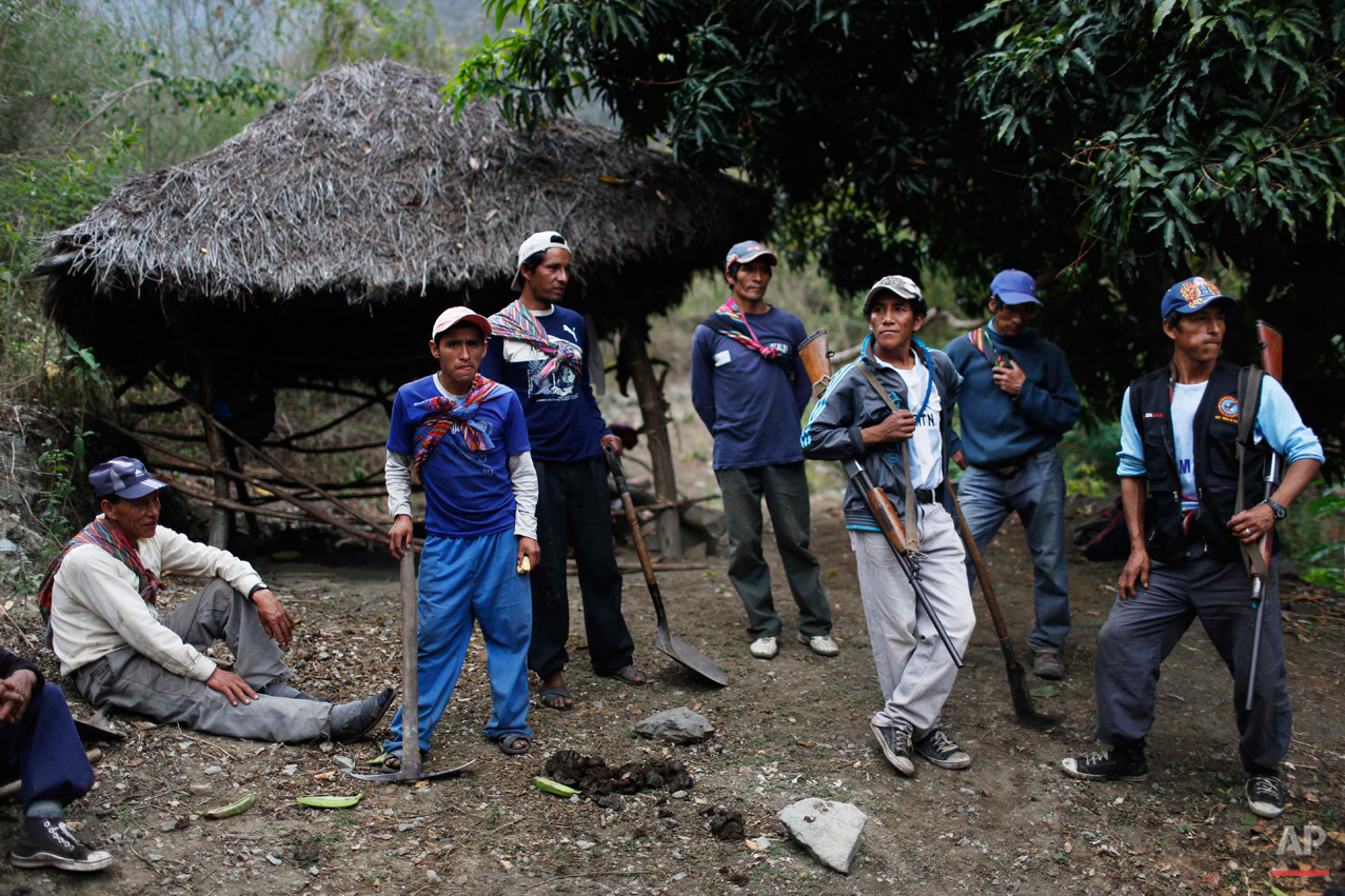  In this Sept. 4, 2014 photo, Belen Chapi Civil Defense Committee members arrive after walking five hours from their village to assist in an exhumation of mass graves with the bodies of villagers slain by security forces, in Paccha village of Peru. B