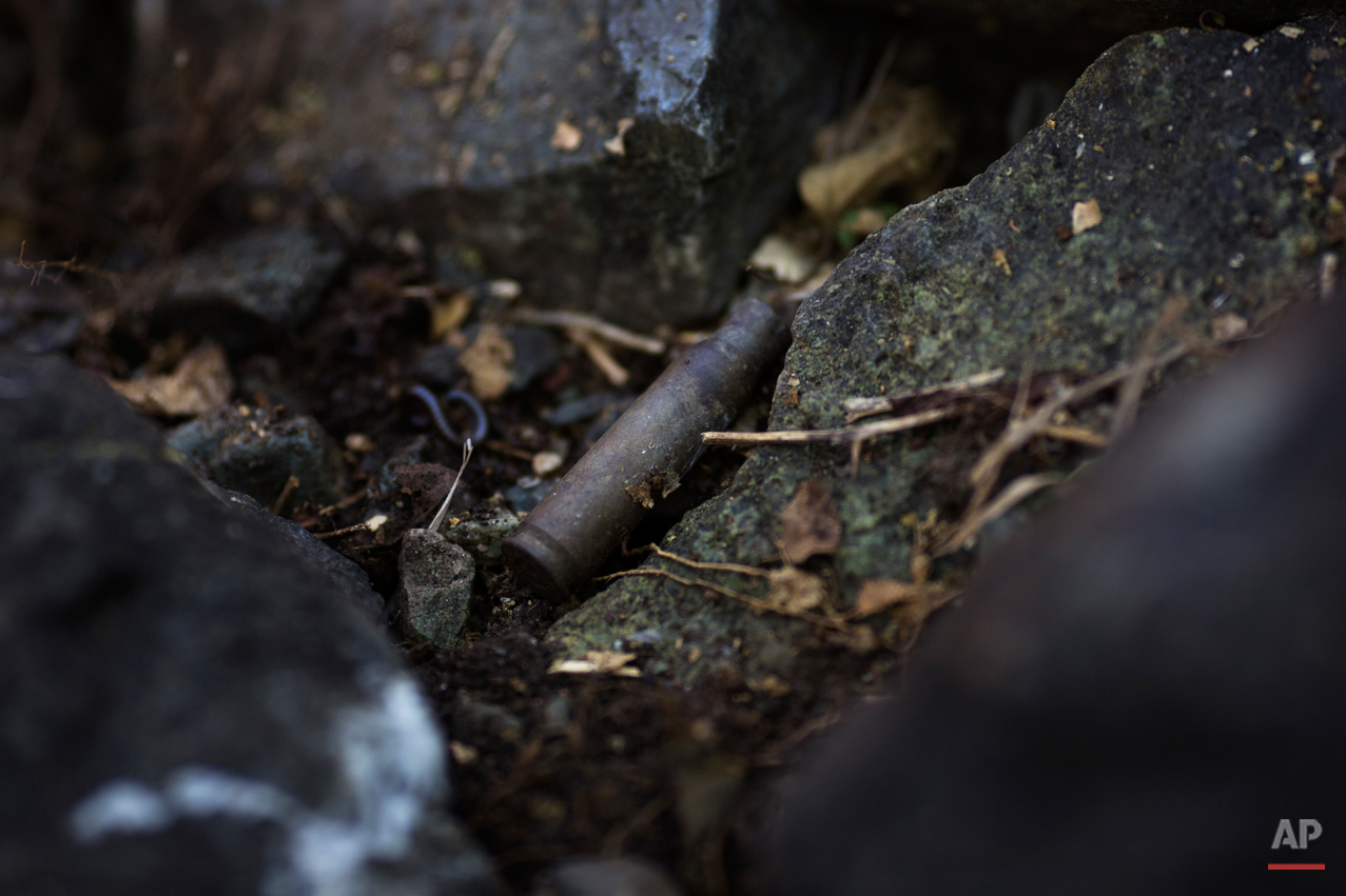  In this Sept. 7, 2014 photo, a spent bullet casing is seen in an unearthed grave during an exhumation of mass graves of villagers slain by security forces, in the Paccha village of Peru. The exhumation was part of an effort by the Peruvian governmen
