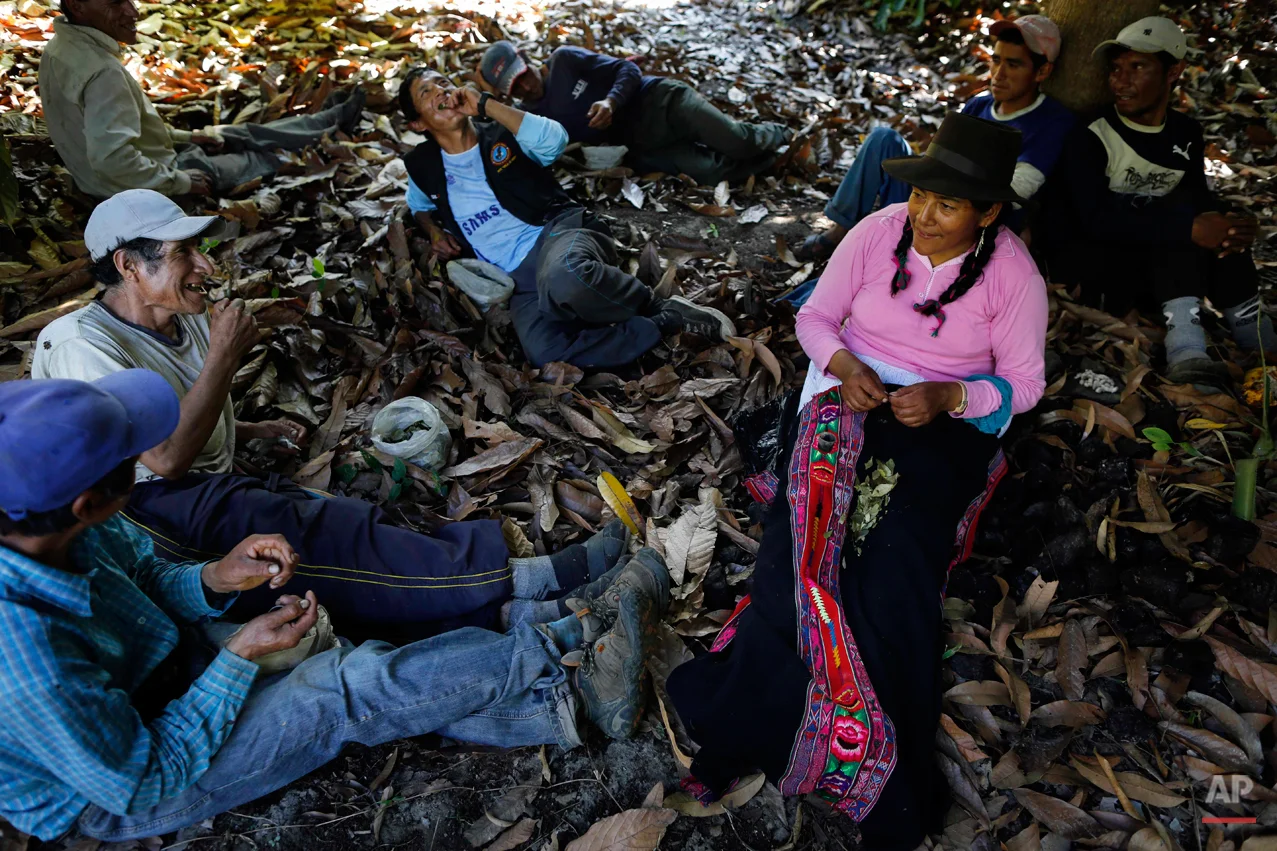 In this Sept. 4, 2014 photo, Dolores Guzman chews coca leaves after eating lunch with villagers hired by forensic anthropologists to assist in an exhumation of mass graves of people slain by government security forces in the Paccha village of Peru. Guzman, sole survivor of the 1984 massacre, journeyed to Paccha to help in locating the common graves. She was spared, she says, because one of her cousins was a police guide. The day after the killings, she was marched out of the village and released. (AP Photo/Rodrigo Abd)