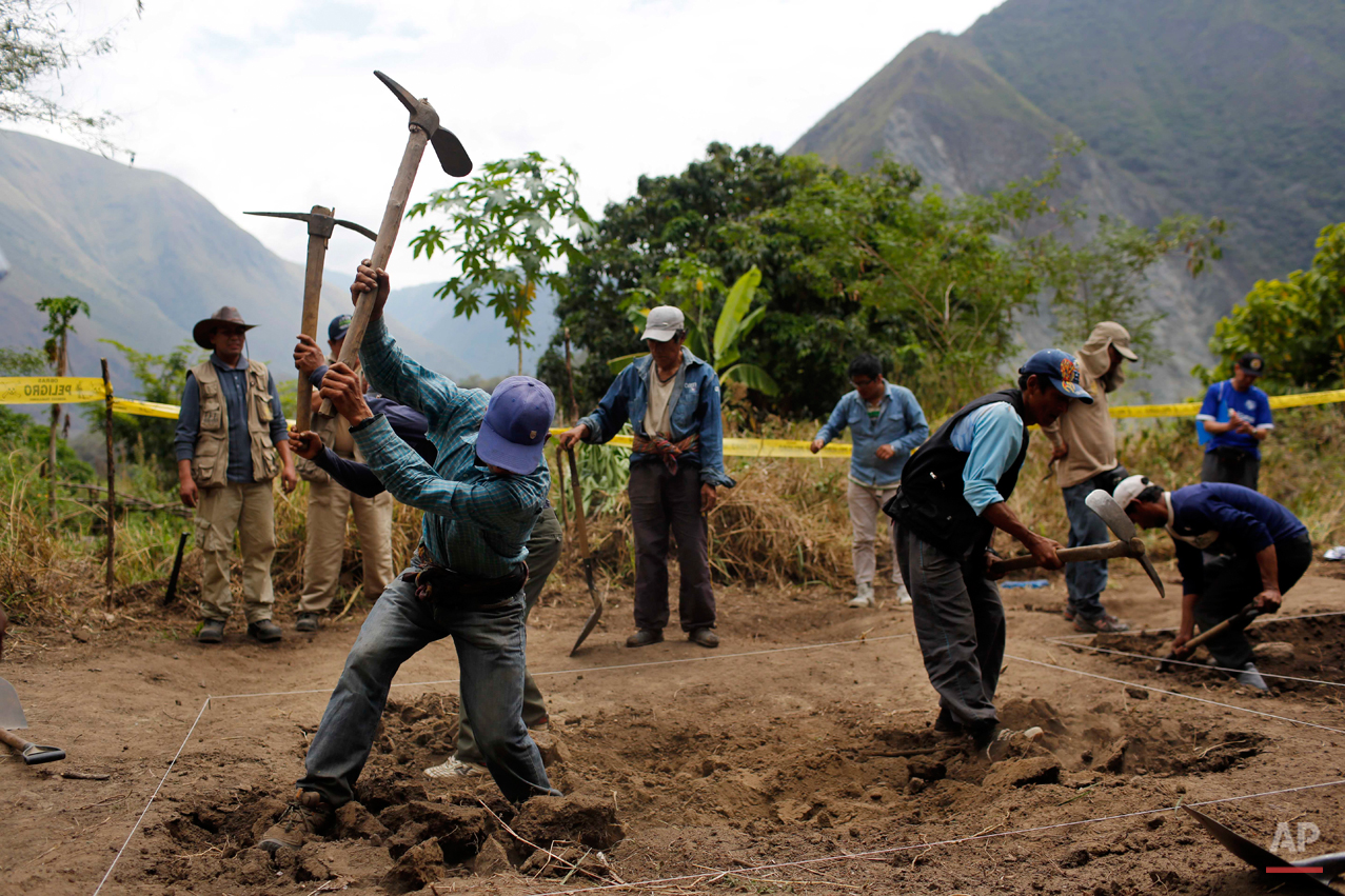  In this Sept. 4, 2014 photo, Belen Chapi Civil Defense Committee members begin digging an area mapped by forensic anthropologists in an exhumation of mass graves of villagers slain by security forces, in the Paccha village of Chungui, Peru. The exhu