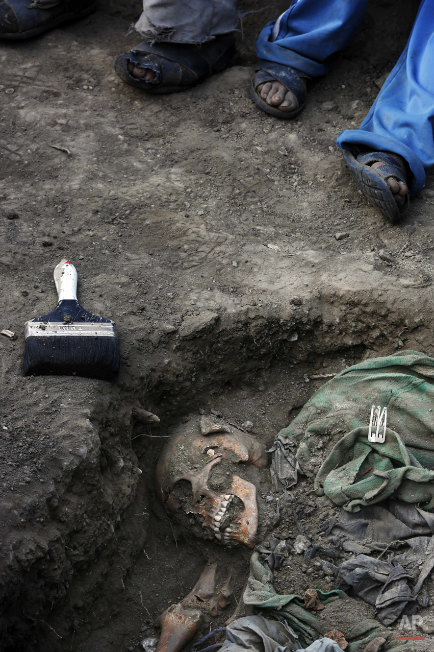  In this Sept. 4, 2014 photo, villagers hired by forensic anthropologists take a break from helping the exhumation of mass graves of people slain by government security forces in 1984, in the Paccha village of Peru. After more than a week of digging,