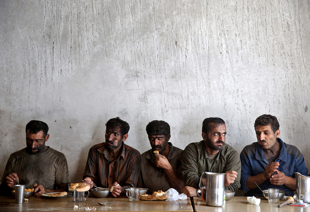  In this Tuesday, Aug. 19, 2014 photo, Iranian coal miners eat lunch at a mine near the city of Zirab 212 kilometers (132 miles) northeast of the capital Tehran, on a mountain in Mazandaran province, Iran. International sanctions linked to the decade