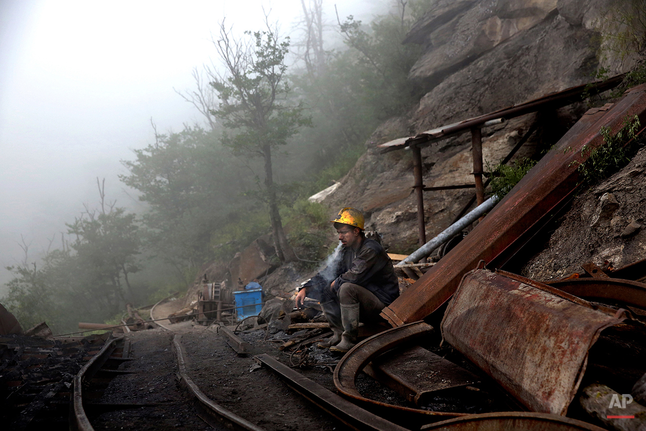  In this Thursday, May 8, 2014 photo, an Iranian coal miner takes a break at a mine near the city of Zirab 212 kilometers (132 miles) northeast of the capital Tehran, on a mountain in Mazandaran province, Iran.  International sanctions linked to the 