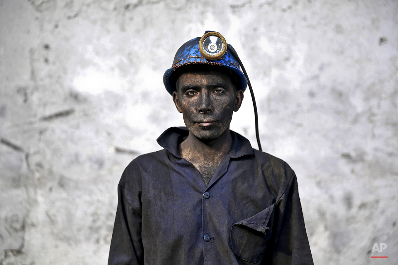  In this Wednesday, May 7, 2014 photo, an Iranian coal miner with his face smeared black from coal poses for a photograph at a mine near the city of Zirab 212 kilometers (132 miles) northeast of the capital Tehran, on a mountain in Mazandaran provinc