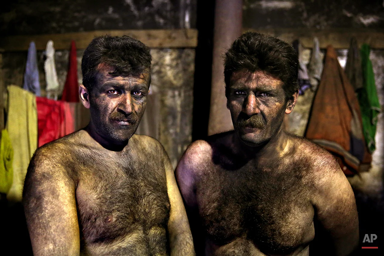 In this Wednesday, May 7, 2014 photo, Iranian coal miners pose for a photograph before taking a shower after a long day of work at a mine on a mountain in Mazandaran province, near the city of Zirab 212 kilometers (132 miles) northeast of the capital Tehran Iran. The miners put in long hours in often dangerous conditions making just $300 a month, little more than minimum wage. (AP Photo/Ebrahim Noroozi)