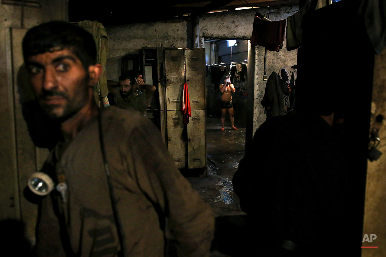  In this Tuesday, May 6, 2014 photo, an Iranian coal miner takes a shower while others prepare to go home after a long day of work at a mine on a mountain in Mazandaran province, near the city of Zirab, 212 kilometers (132 miles) northeast of the cap