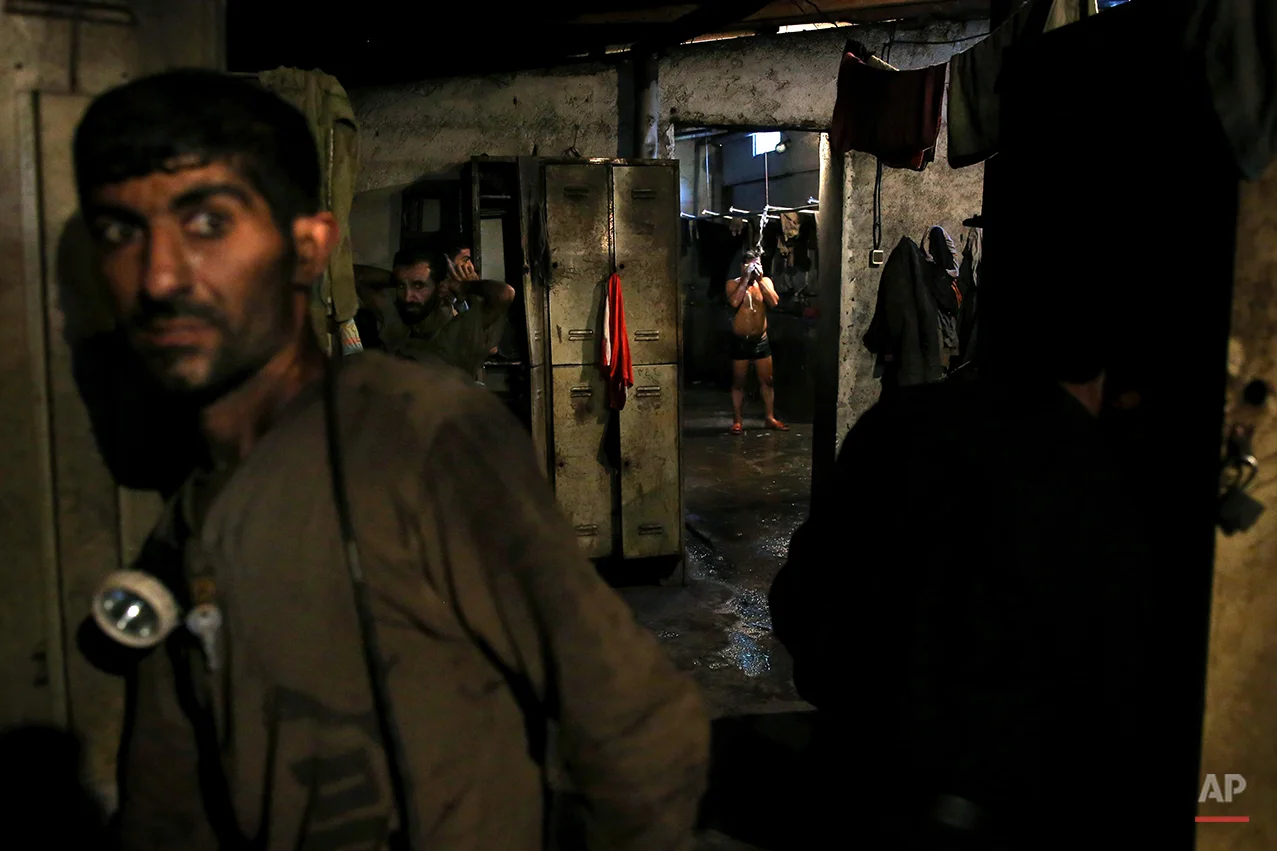 In this Tuesday, May 6, 2014 photo, an Iranian coal miner takes a shower while others prepare to go home after a long day of work at a mine on a mountain in Mazandaran province, near the city of Zirab, 212 kilometers (132 miles) northeast of the capital Tehran Iran. Around 1,200 miners work across 10 mines in the Mazandaran province, in a mountainous, verdant area. More than 12,000 tons of coal is extracted from the mines each month, almost all of which is shipped south for use in Iran’s steel industry. (AP Photo/Ebrahim Noroozi)