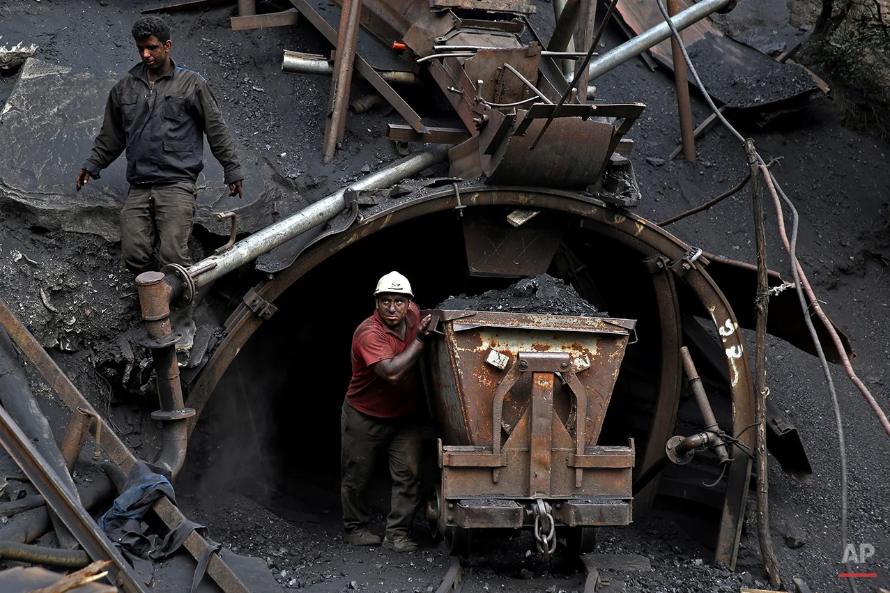 In this Monday, Aug. 18, 2014 photo, an Iranian coal miner pushes a metal cart loaded with coal at a mine near the city of Zirab 212 kilometers (132 miles) northeast of the capital Tehran, on a mountain in Mazandaran province, Iran. The miner move up to 100 tons of coal a day. (AP Photo/Ebrahim Noroozi)