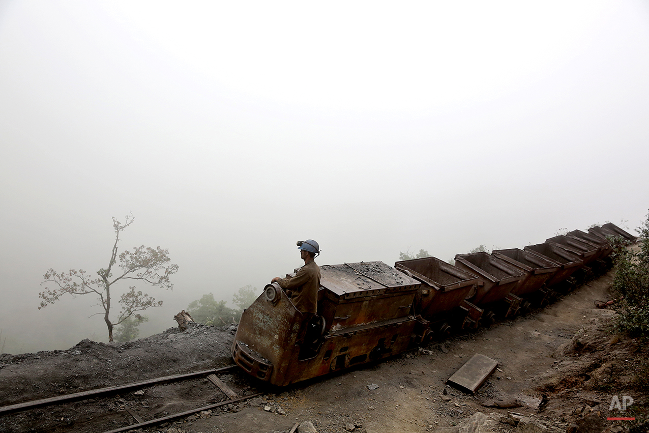  In this Thursday, May 8, 2014 photo, an Iranian coal miner moves wagons to be loaded with coal at a mine near the city of Zirab 212 kilometers (132 miles) northeast of the capital Tehran, on a mountain in Mazandaran province, Iran. International san