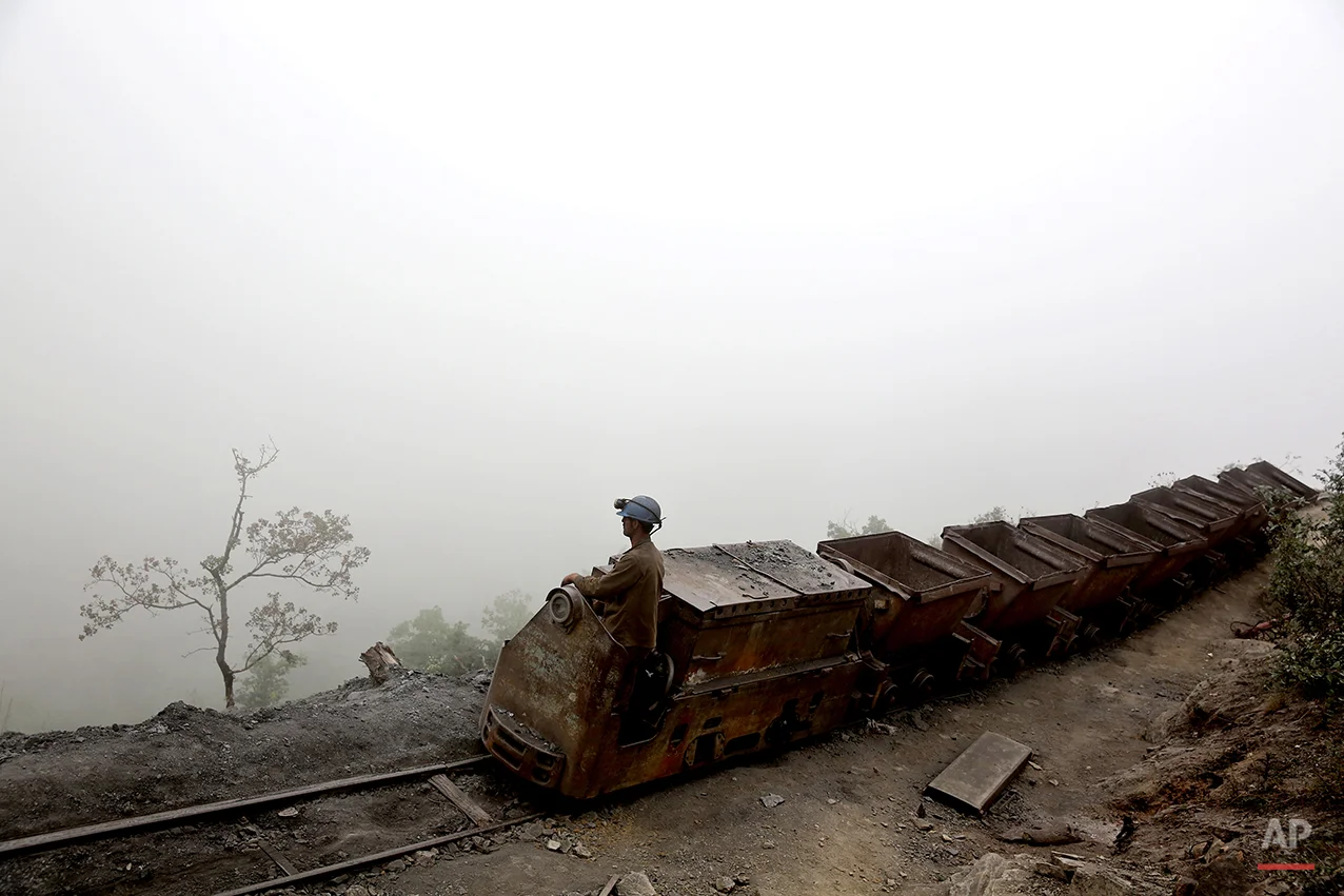 In this Thursday, May 8, 2014 photo, an Iranian coal miner moves wagons to be loaded with coal at a mine near the city of Zirab 212 kilometers (132 miles) northeast of the capital Tehran, on a mountain in Mazandaran province, Iran. International sanctions linked to the decade-long dispute over Iran’s nuclear program have hindered the import of heavy machinery and modern technology in all sectors, and coal mining is no exception. (AP Photo/Ebrahim Noroozi)