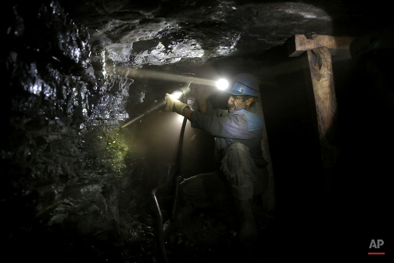  In this Monday, Aug. 18, 2014 photo, an Iranian coal miner works inside a mine near the city of Zirab 212 kilometers (132 miles) northeast of the capital Tehran, on a mountain in Mazandaran province, Iran. The miners tunnel deep into the mountains, 