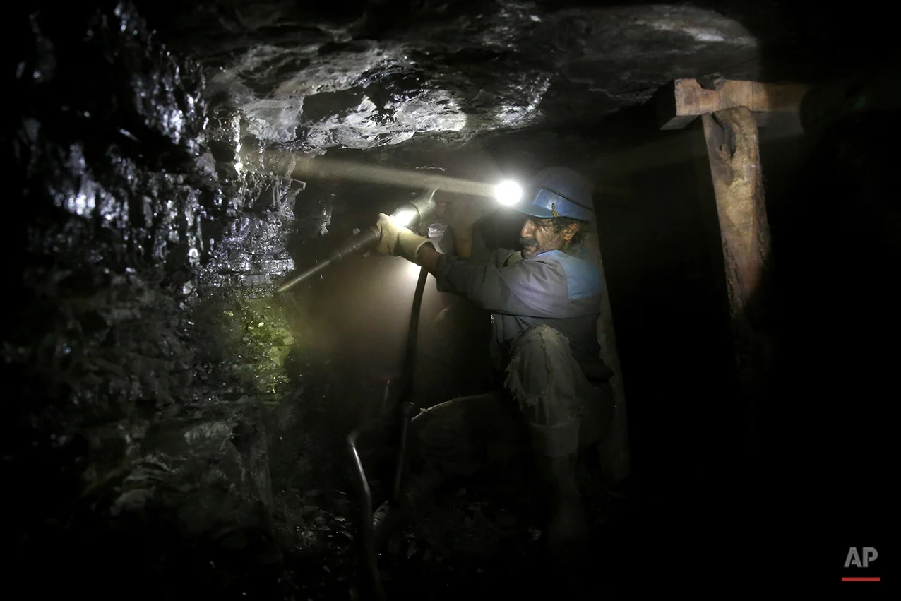 In this Monday, Aug. 18, 2014 photo, an Iranian coal miner works inside a mine near the city of Zirab 212 kilometers (132 miles) northeast of the capital Tehran, on a mountain in Mazandaran province, Iran. The miners tunnel deep into the mountains, working in dark, narrow passageways where the risk of toxic gases and cave-ins is never far from their minds. (AP Photo/Ebrahim Noroozi)