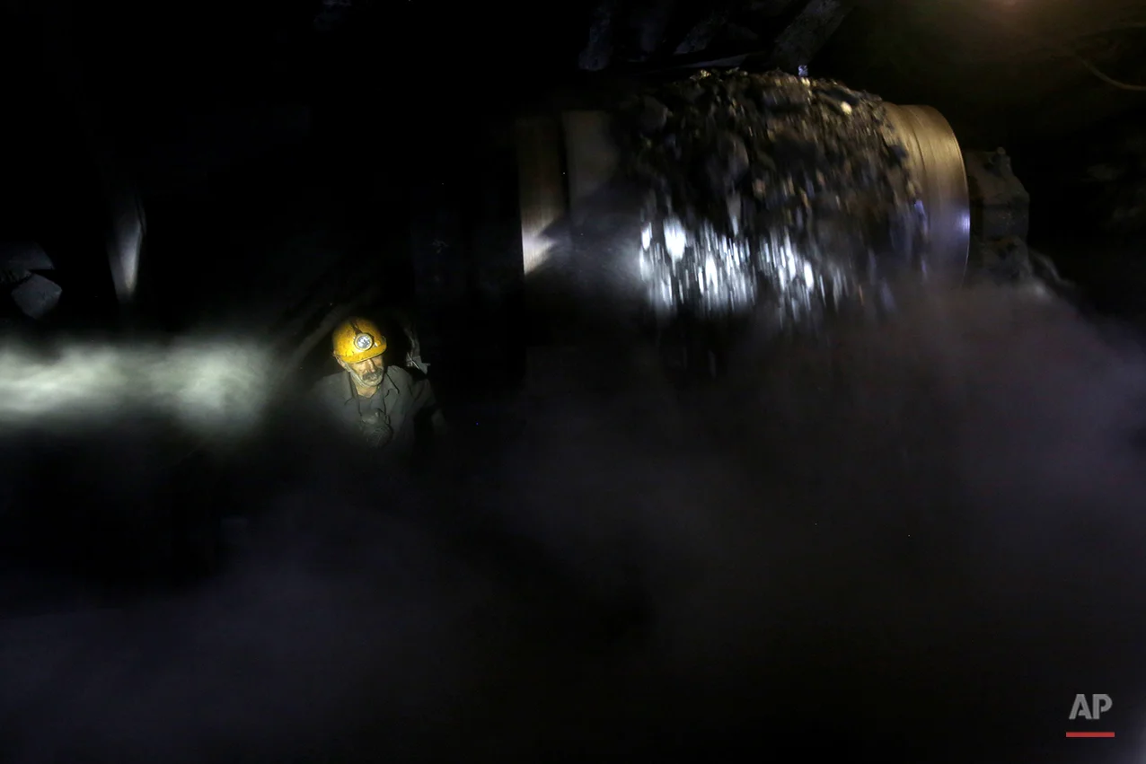 In this Tuesday, Aug. 19, 2014 photo, an Iranian coal miner works inside a mine near the city of Zirab 212 kilometers (132 miles) northeast of the capital Tehran, on a mountain in Mazandaran province, Iran. The miners tunnel deep into the mountains, working in dark, narrow passageways where the risk of toxic gases and cave-ins is never far from their minds. (AP Photo/Ebrahim Noroozi)