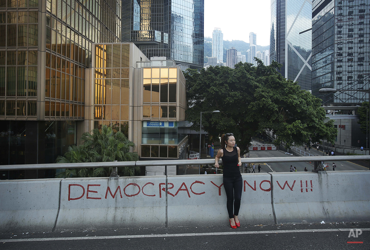  A woman rests on an overpass closed due to a massive protest in Hong Kong, Monday, Sept. 29, 2014. Pro-democracy protesters expanded their rallies throughout Hong Kong on Monday, defying calls to disperse in a major pushback against Beijing's decisi