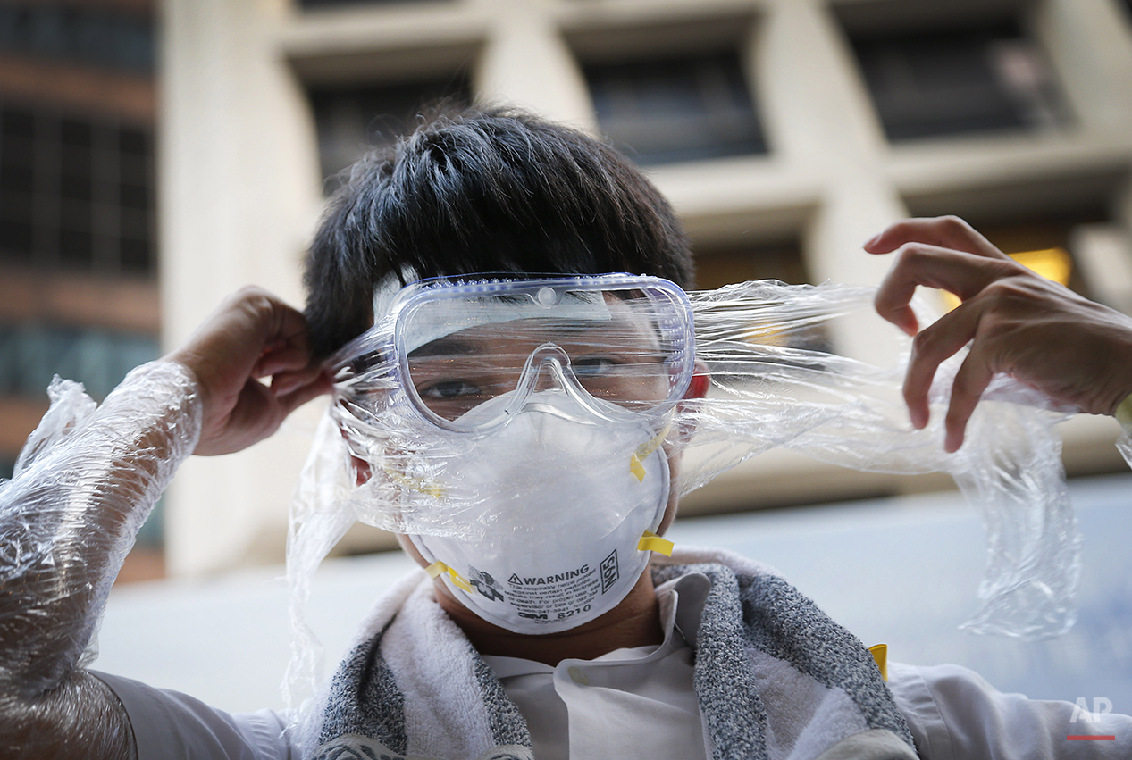  A student pro-democracy protester covers his face in plastic wrap to protect against pepper spray in the event that it is used as they stand-off with local police, Monday, Sept. 29, 2014 in Hong Kong. Pro-democracy protesters expanded their rallies 