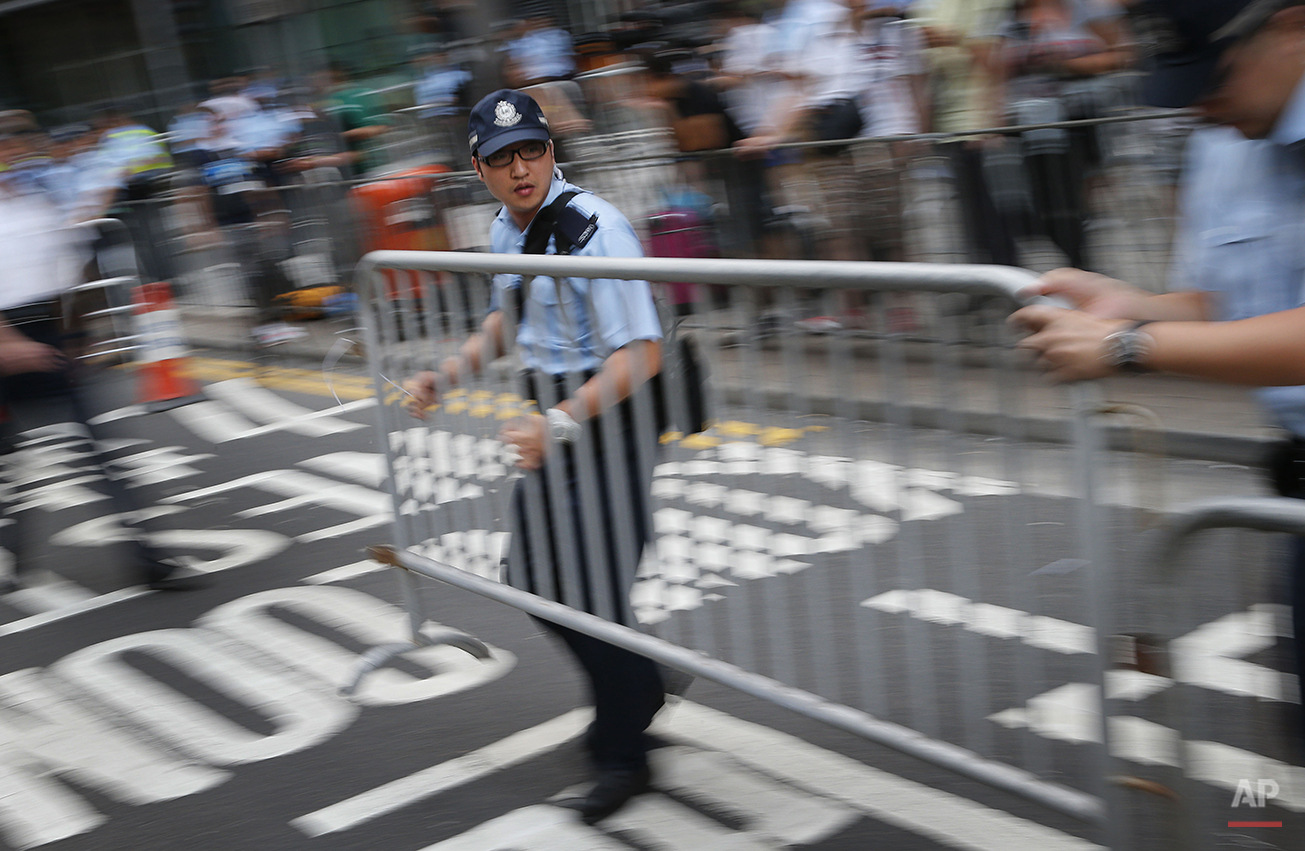  Policemen set up metal barricades in efforts to keep pro-democracy protesters at bay in Hong Kong Monday, Sept. 29, 2014. Protesters expanded their rallies throughout Hong Kong on Monday, defying calls to disperse in a major pushback against Beijing