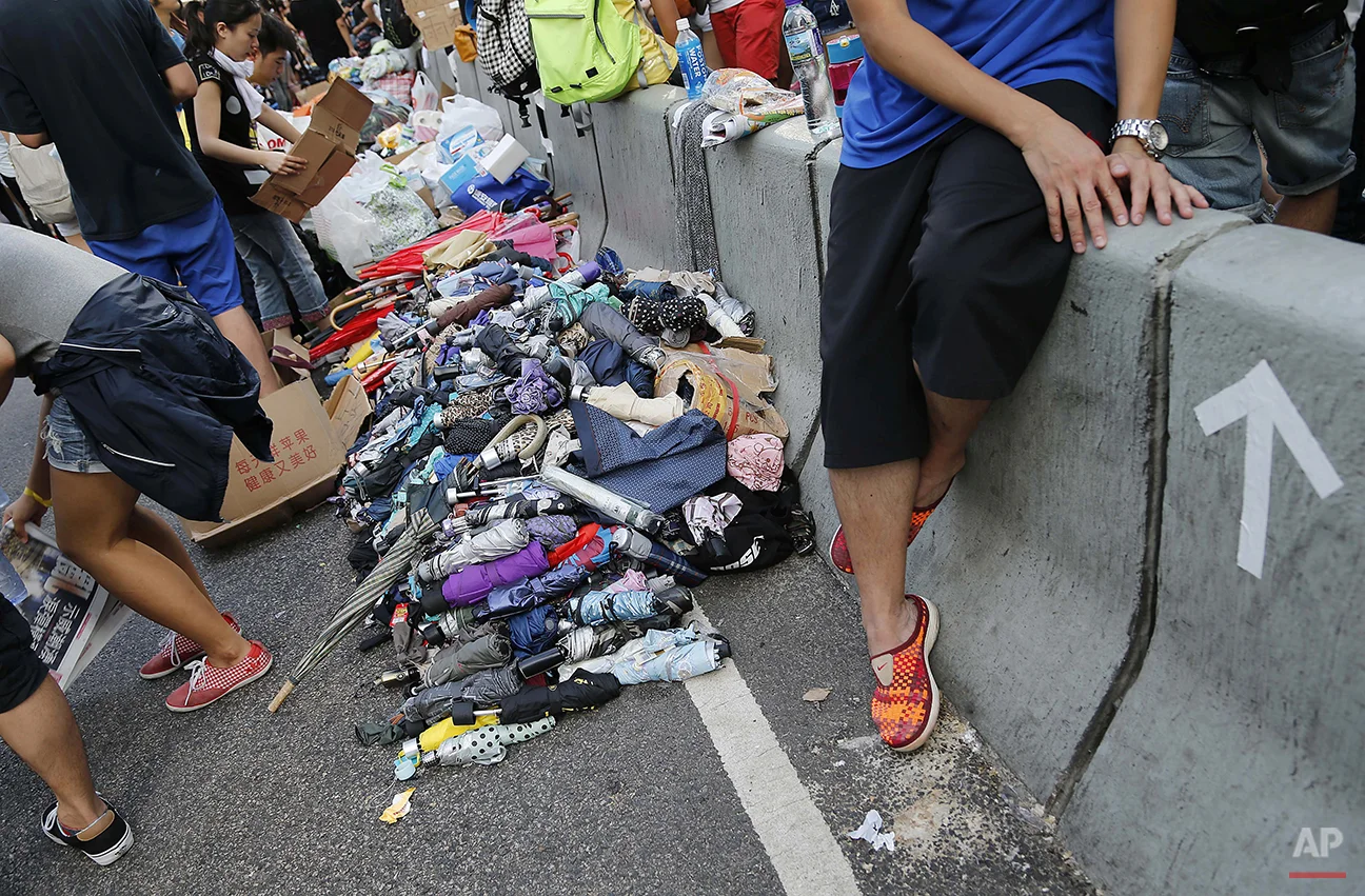 Stacks of umbrellas are ready for pro-democracy protesters' use to shield themselves from pepper spray Monday, Sept. 29, 2014 in Hong Kong. Protesters expanded their rallies throughout Hong Kong on Monday, defying calls to disperse in a major pushback against Beijing's decision to limit democratic reforms in the Asian financial hub. (AP Photo/Wong Maye-E)