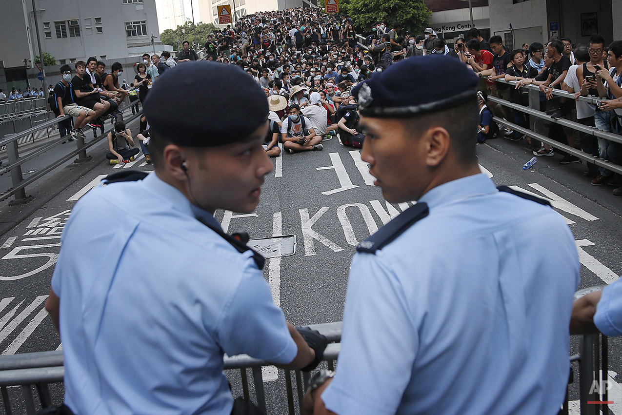  Pro-democracy protesters sit on a road as they face-off with local police, Monday, Sept. 29, 2014 in Hong Kong. Pro-democracy protesters expanded their rallies throughout Hong Kong on Monday, defying calls to disperse in a major pushback against Bei