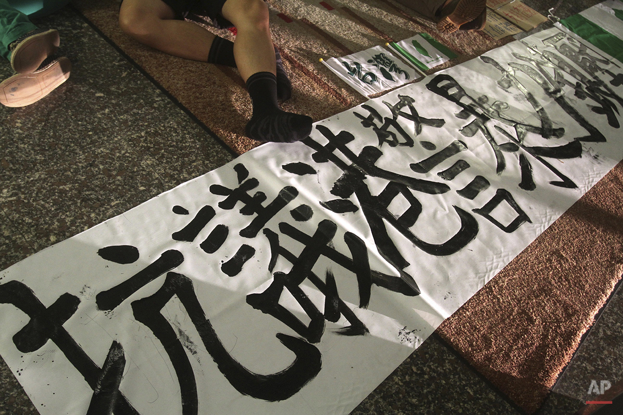  A student demonstrator supporting pro-democracy protests taking place in Hong Kong sleeps with a banner reading "Protest Hong Kong Police brutal force" on the floor as they occupy the first floor of Hong Kong Economic, Trade and Cultural Office in T