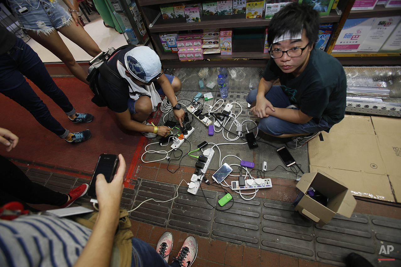  Student protesters connect electric extension cords to charge their phones during a sit-in protest in Hong Kong, Monday, Sept. 29, 2014. Pro-democracy protesters expanded their rallies throughout Hong Kong on Monday, defying calls to disperse in a m