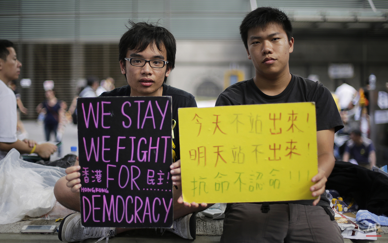  Student protesters sit with signs on their fight for democracy in Hong Kong Wednesday, Oct. 1, 2014. Holiday crowds swelled into the tens of thousands as student leaders met with other pro-democracy protesters Wednesday to thrash out a strategy for 