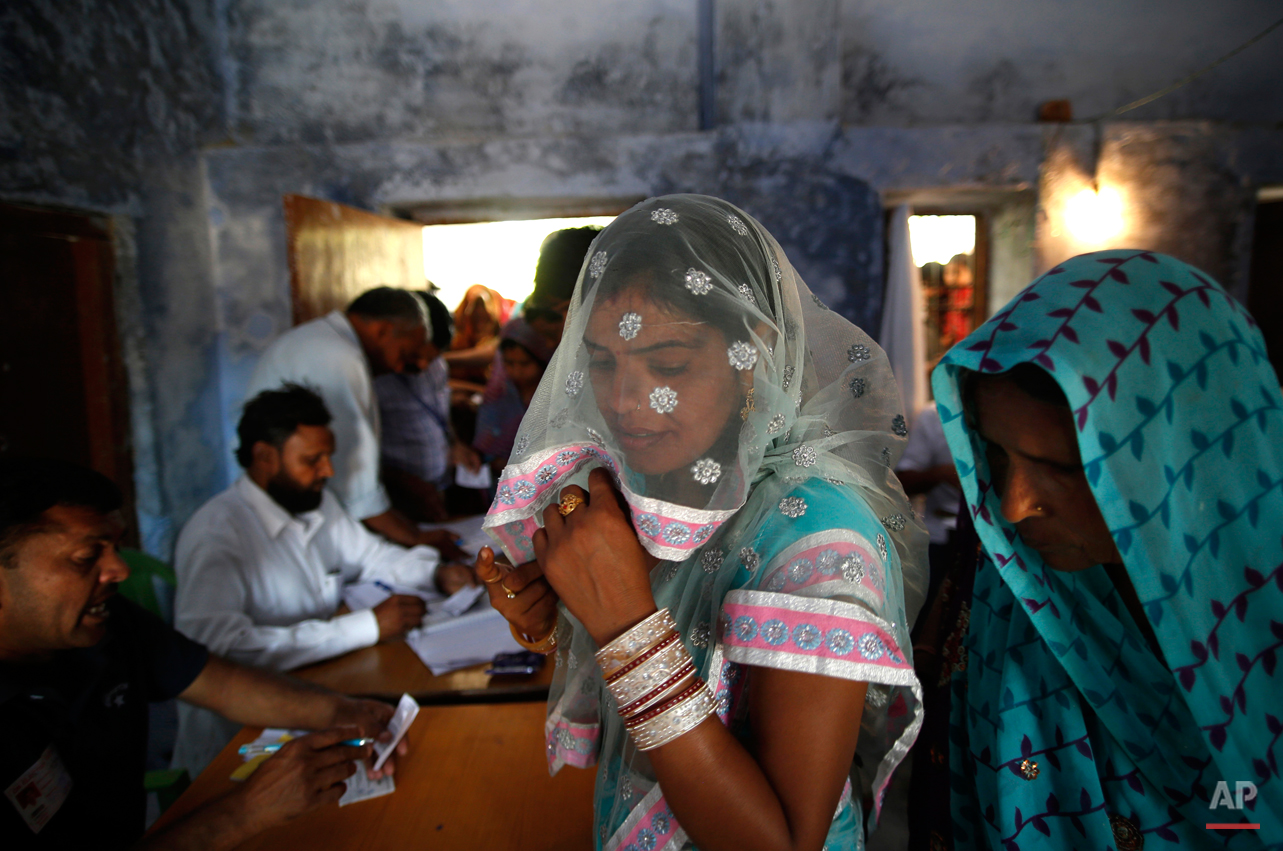  Female voters wait for their identities to be verified before being allowed to vote in Ujina, in the Indian state of Haryana, Thursday, April 10, 2014. Indians voted in the crucial third phase of national elections Thursday, with millions going to t