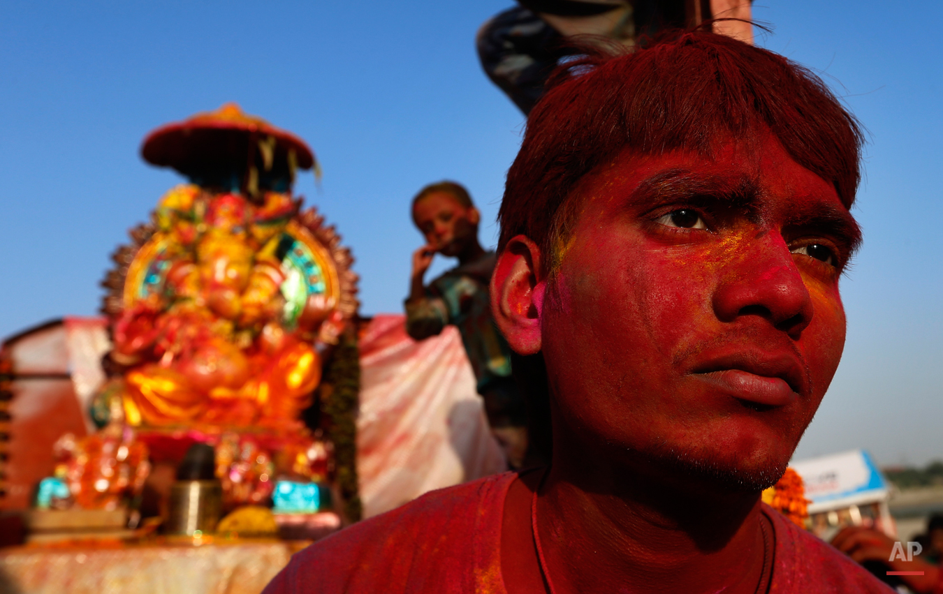  An Indian man sits with a statue of elephant headed Hindu God Ganesha before its immersion into the River Yamuna in New Delhi, India, Wednesday, Sept. 18, 2013. The immersion marks the end of the ten-day long Ganesh Chaturthi festival that celebrate