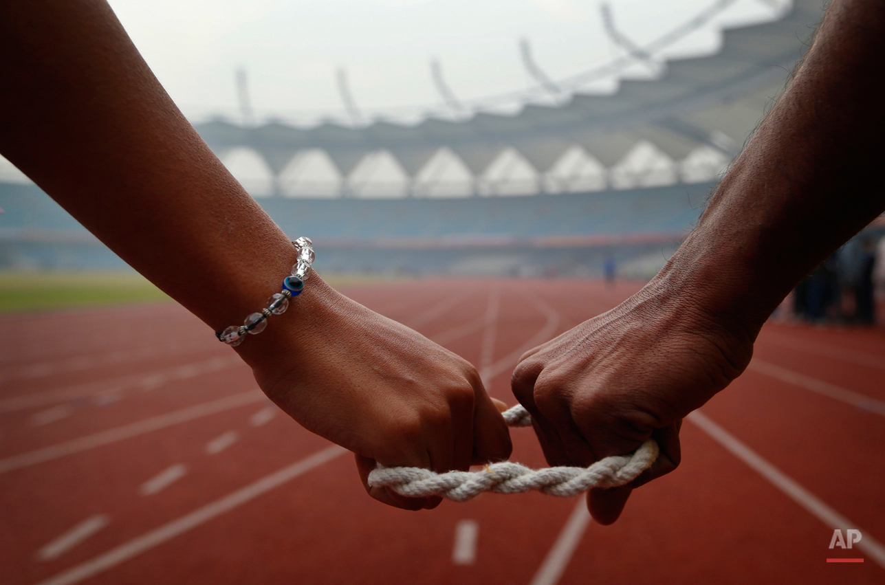  In this Tuesday, Dec. 11, 2012 photo, a blind athlete, left, is connected to her guide as she gets ready to run during the 18th National Sports Meet for the Blind in New Delhi, India. The four day event ends Friday. (AP Photo/Saurabh Das) 