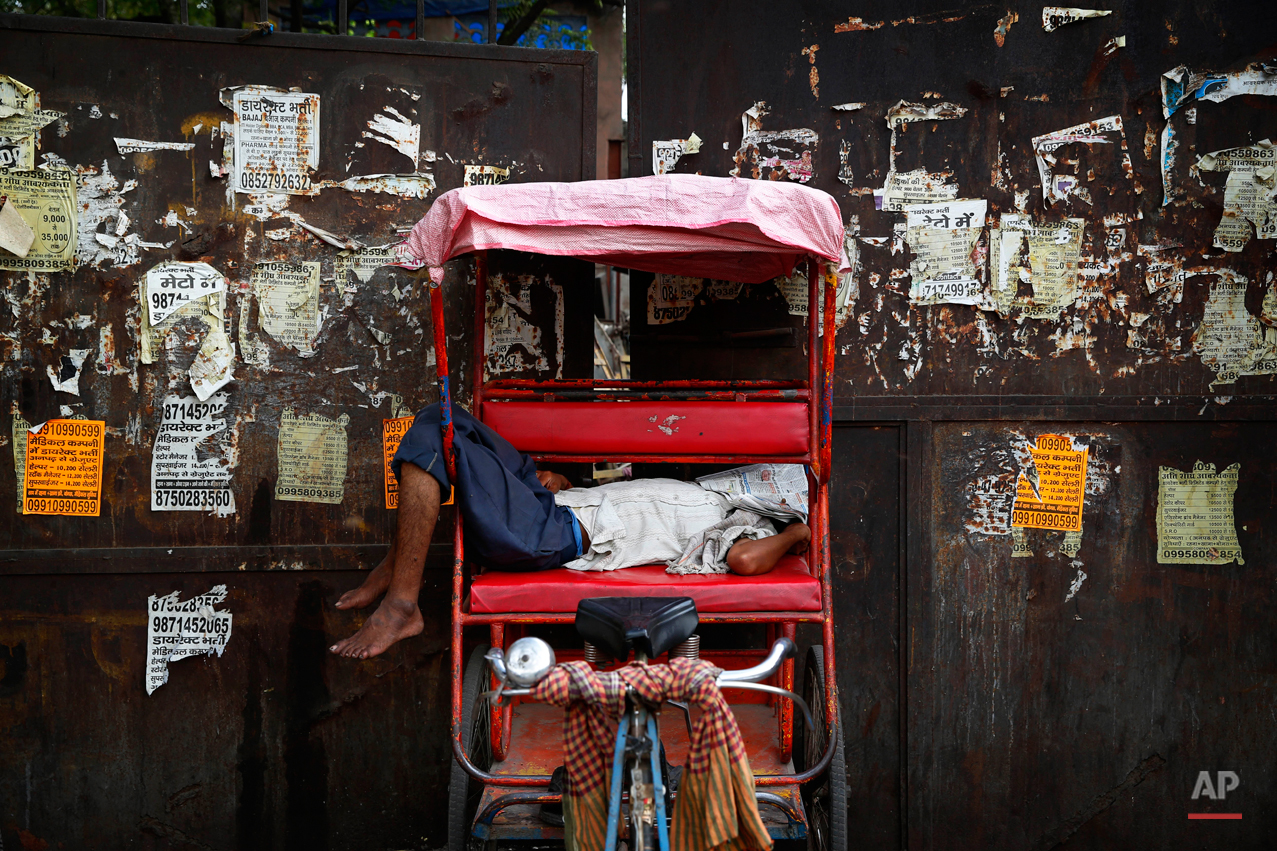  A rickshaw puller covers his face with a newspaper as he takes a nap in a hot summer afternoon in New Delhi, India, Friday, May 2, 2014. Daytime temperatures touched 42 degrees Celsius (108 degrees Fahrenheit). (AP Photo/Saurabh Das) 