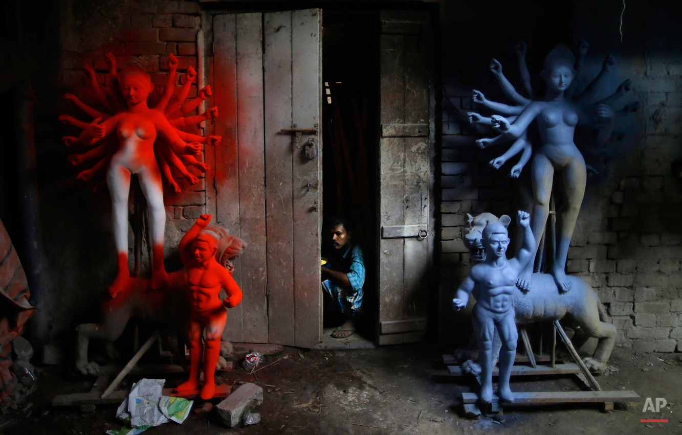  A laborer looks out of a workshop that prepares idols of goddess Durga in Kolkata, India, Tuesday, Oct. 16, 2012. Durga Puja, the festival dedicated to the worship of Goddess Durga begins on Oct. 20 and will continue until Oct. 24. (AP Photo/Saurabh