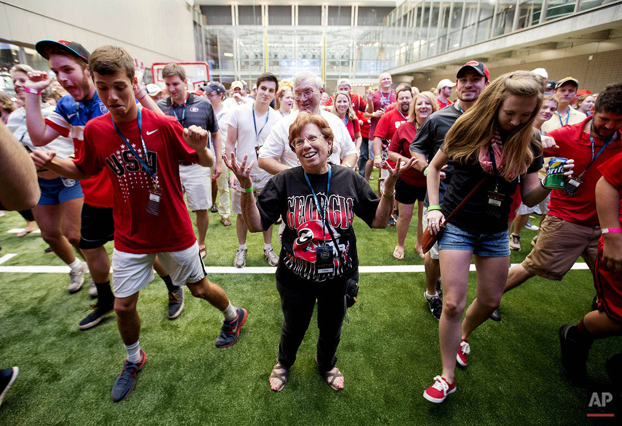  Lyn Grossman, of Smyrna Ga., throws her hands up in the air while trying to keep up with a dance move during a sleepover in the College Football Hall of Fame, Wednesday, Aug. 13, 2014, in Atlanta. Guests competed in dance competitions to win prizes 