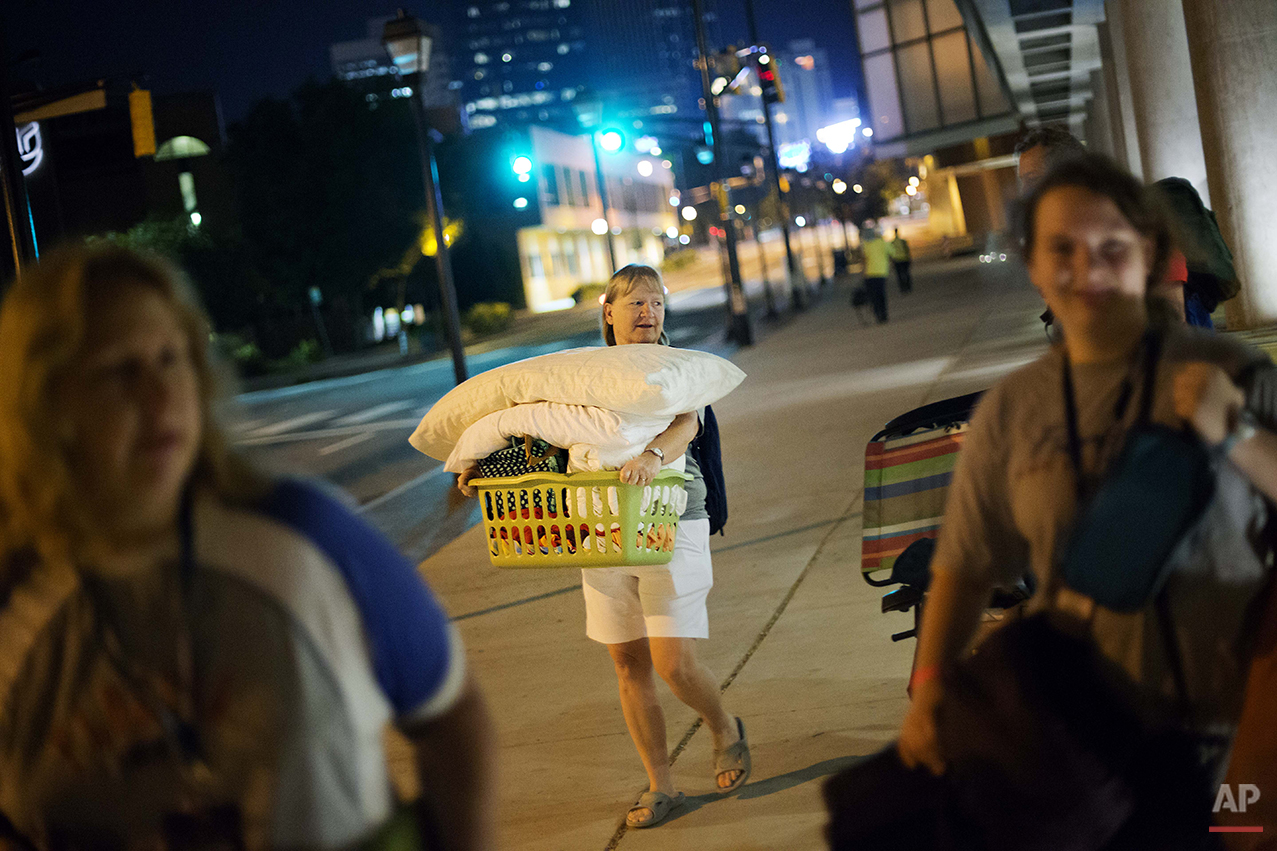 Jodi Huizenga, of Fort Lauderdale, Fla., carries out her belongings after a sleepover in the College Football Hall of Fame, Thursday, Aug. 14, 2014, in Atlanta. The hall was previously located in South Bend, Ind., but was plagued by poor attendance.