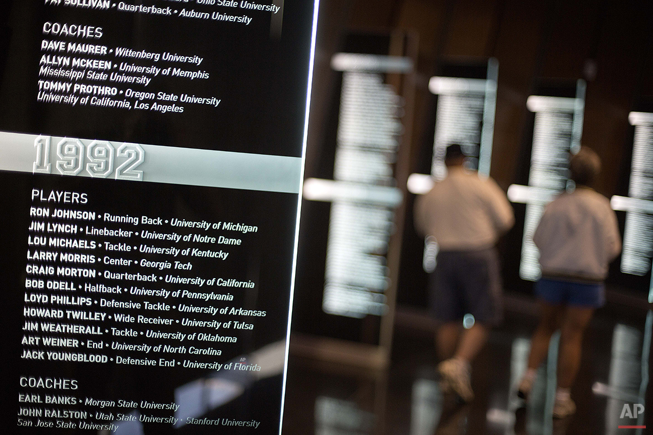  Names of inductees from 1992 are displayed as guests tour the College Football Hall of Fame, Wednesday, Aug. 13, 2014, in Atlanta. Visitors can use touch screens to access individual profiles of more than 1,100 players and coaches that are enshrined