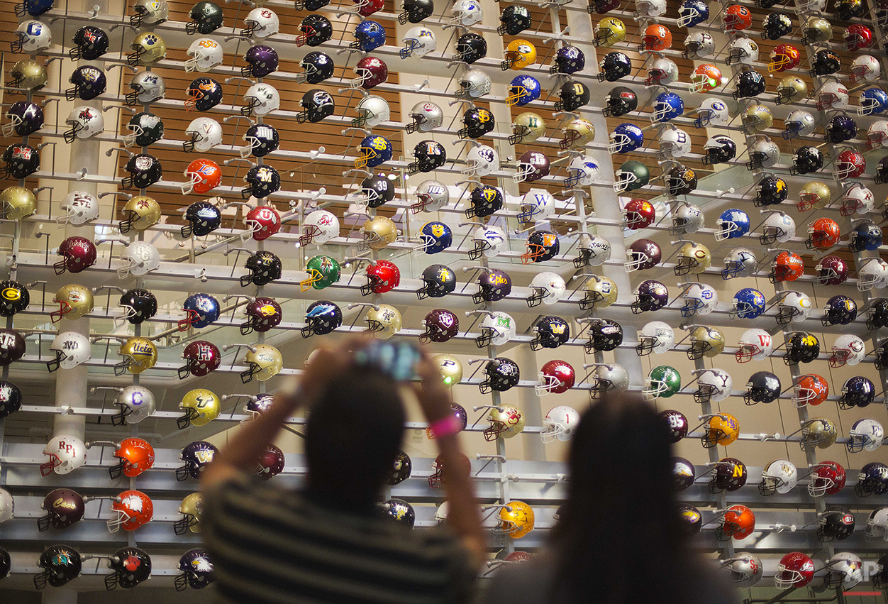 Helmets representing the 768 college football programs in the U.S. are displayed as fans arrive to spend the night in the College Football Hall of Fame, Wednesday, Aug. 13, 2014, in Atlanta. The school associated with a fan's registration card will 
