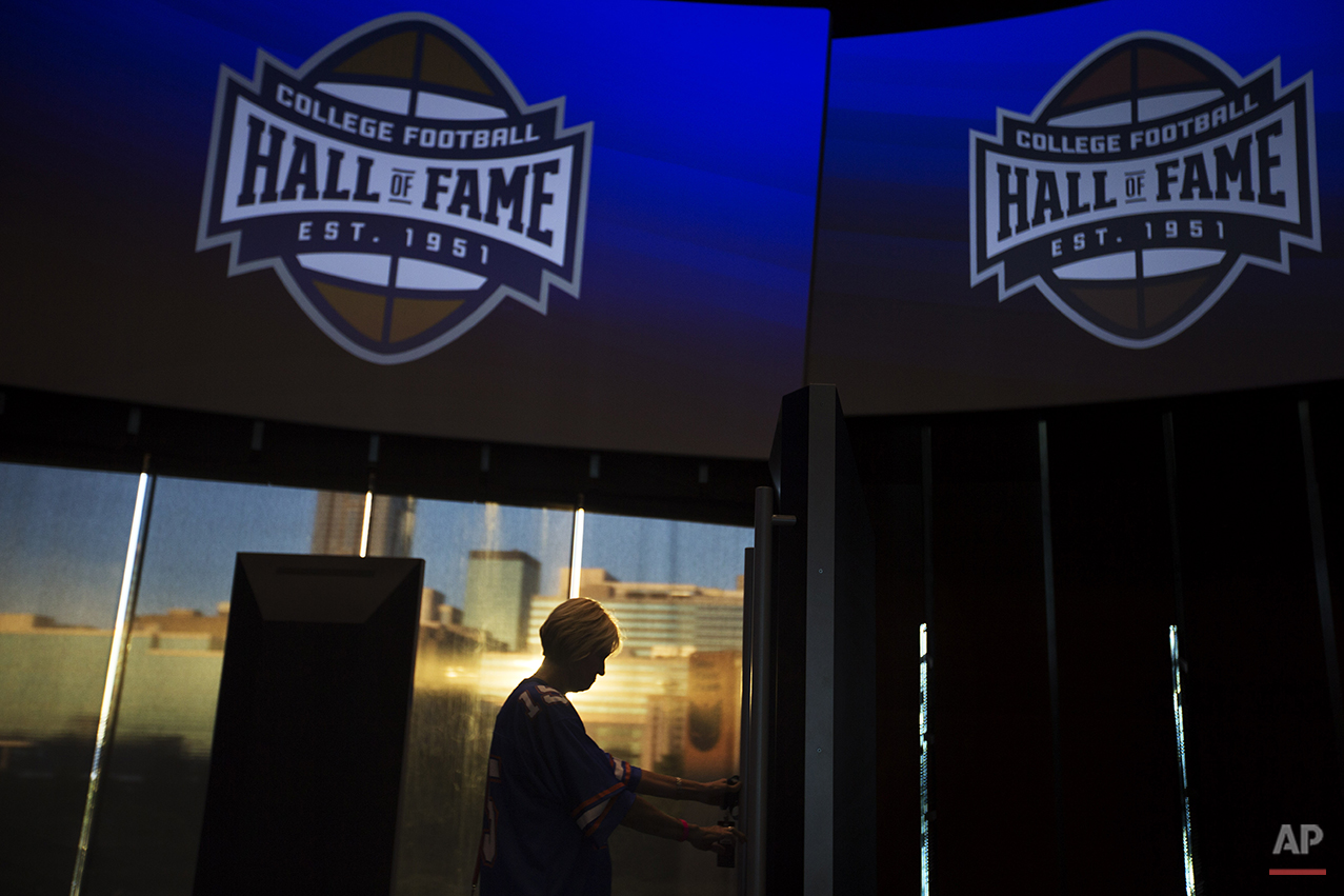  Valerie Herriman, of Augusta, Ga., tours the College Football Hall of Fame before spending the night there as the sun sets against the downtown skyline in the background, Wednesday, Aug. 13, 2014, in Atlanta. One hundred contest winners who wrote an