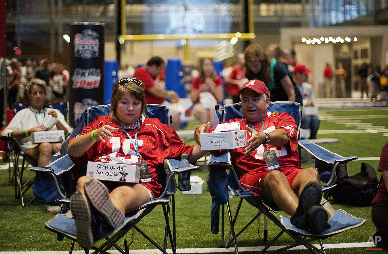  Amy, left, and Louis Valenzuela, of Marietta, Ga., sit down to eat dinner on the turf as part of a sleepover in the College Football Hall of Fame, Wednesday, Aug. 13, 2014, in Atlanta. "It's awesome," said Amy, an Alabama fan. "I think I already pul