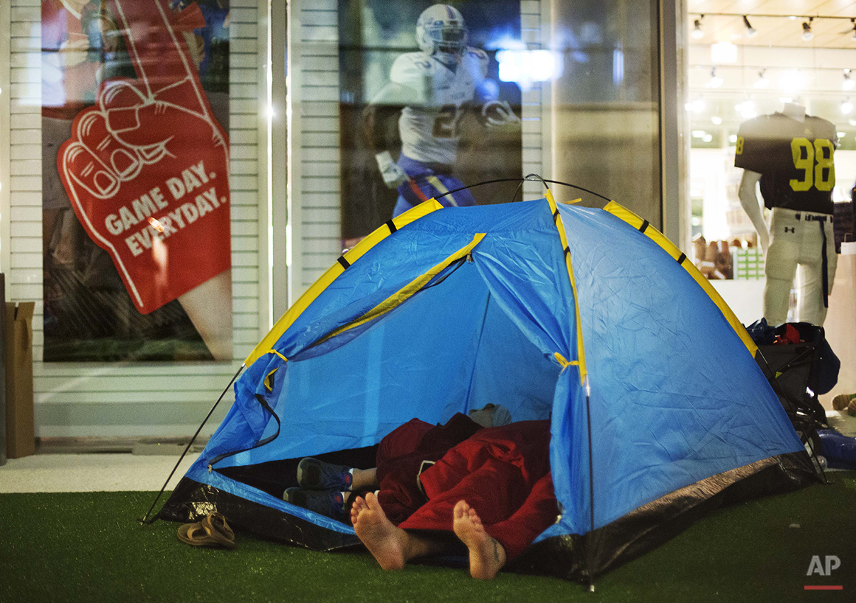  Guests sleep in a tent next to the gift shop during a sleepover in the College Football Hall of Fame, Thursday, Aug. 14, 2014, in Atlanta. After touring the exhibits guest were served dinner on the football field before pitching their tents on the t