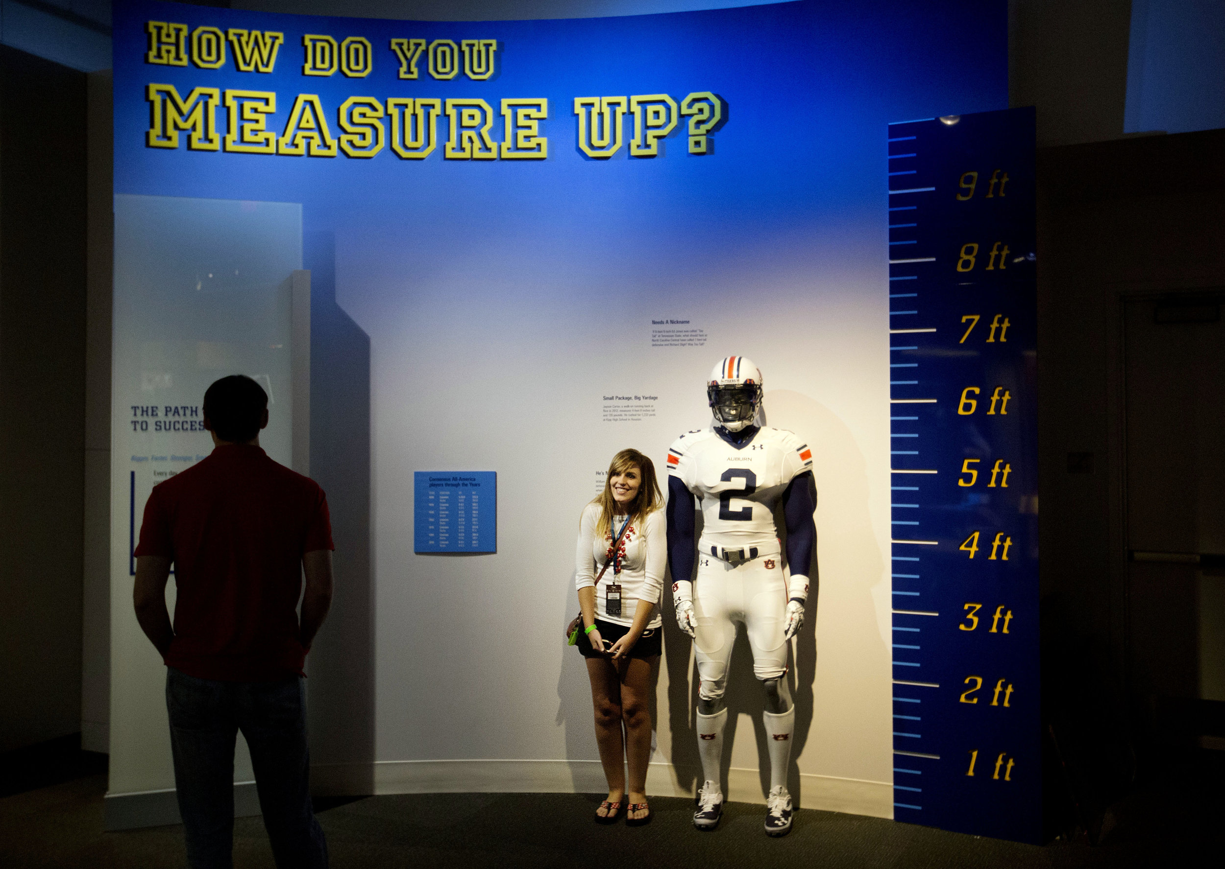  Joanna Jinright, of Dalton, Ga., right, measures herself next to a mannequin of a football player as Anders Ravenholt, of Chattanooga, Tenn., left, looks on during a tour of the College Football Hall of Fame, Wednesday, Aug. 13, 2014, in Atlanta. On